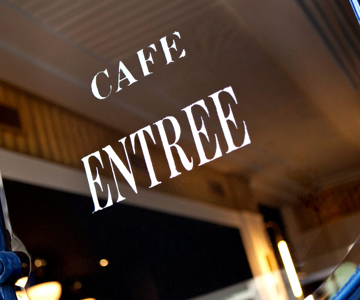 A cafe doorway, gilt lettering on the glass above a painted iron frame